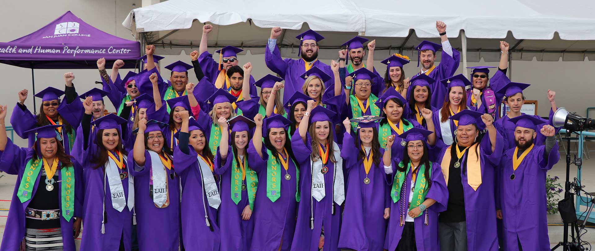 Honor Students at Graduation raising their arm in celebration