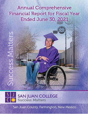 San Juan College Student in wheelchair wearing graduation cap and gown smiling at camera