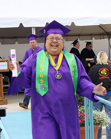 Honor Student at Graduation walking off the stage after receiving diploma