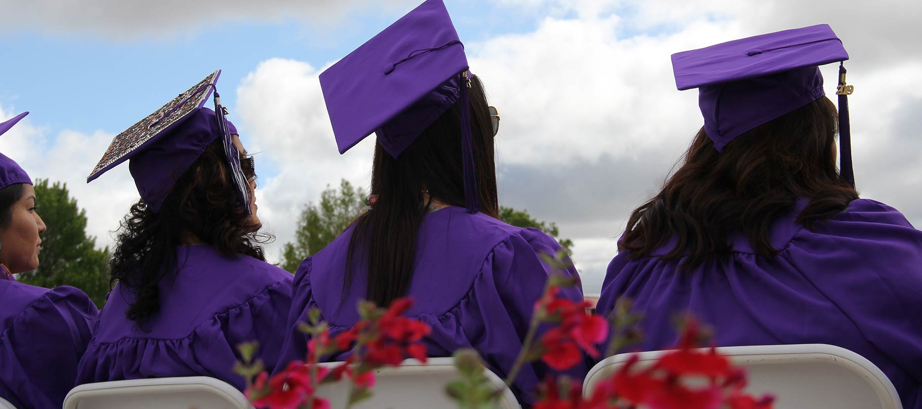 SJC students at graduation looking at the future.  Back on students with graduation cap and gown. 