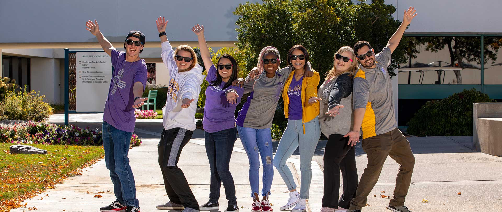 Students wearing SJC gear in the courtyard smiling 